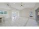 Spacious living room with tile flooring, high ceilings, and sliding glass doors to lanai at 1915 Pebble Beach Ct, Venice, FL 34293