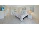 Bright primary bedroom featuring tiled floors, plantation shutters, and a comfortable king bed at 1915 Pebble Beach Ct, Venice, FL 34293