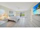 Bright primary bedroom with tiled floors, access to patio and a view of lush landscaping at 1915 Pebble Beach Ct, Venice, FL 34293
