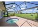 Enclosed patio with in-ground jacuzzi tub and scenic view of golf course in background at 1915 Pebble Beach Ct, Venice, FL 34293