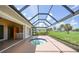 Enclosed patio with a unique octagonal pool and beautiful green space in the background at 1915 Pebble Beach Ct, Venice, FL 34293