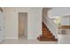 Hallway leading to a wooden staircase and the kitchen features tile flooring for easy maintenance at 200 Valdiva St, Punta Gorda, FL 33983
