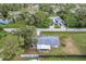 Expansive aerial view of the property showcasing lush greenery, a long driveway, and the home's surrounding landscape at 20409 Emerald Ave, Port Charlotte, FL 33952