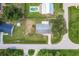 Overhead shot of the property and surrounding neighborhood featuring mature trees and the home's roofline at 20409 Emerald Ave, Port Charlotte, FL 33952
