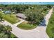 Bird's-eye view of the property with a lush lawn, long driveway, and a welcoming front facade at 20409 Emerald Ave, Port Charlotte, FL 33952