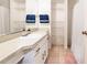 Bright bathroom with a mirror over the sink and storage shelves at 20409 Emerald Ave, Port Charlotte, FL 33952