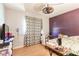 A cozy bedroom featuring a bed, a ceiling fan, and window with curtains at 20409 Emerald Ave, Port Charlotte, FL 33952