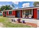 Cozy front porch with wicker chairs, gray front door, and landscaping at 20409 Emerald Ave, Port Charlotte, FL 33952