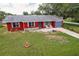 Charming single-Gathering home with a well-manicured front yard, blue garage door, and quaint front porch seating at 20409 Emerald Ave, Port Charlotte, FL 33952