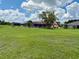 Spacious backyard with a well-maintained lawn, mature trees, and a screened lanai for relaxed outdoor living at 214 Castile Ct, Punta Gorda, FL 33983