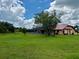 Expansive backyard with lush green grass, screened lanai and mature trees offering a serene outdoor space at 214 Castile Ct, Punta Gorda, FL 33983