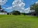 Lush backyard features well-manicured lawn, mature trees, and space between homes providing a private oasis at 214 Castile Ct, Punta Gorda, FL 33983