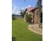 A view of the home's side and backyard with well-manicured lawn, landscaping and exterior at 214 Castile Ct, Punta Gorda, FL 33983