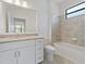 Bright bathroom featuring a granite countertop vanity, a toilet, and a tiled bathtub at 2161 Gardenia Ave, Port Charlotte, FL 33953