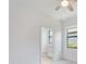 Bright bedroom with a ceiling fan, window, and doorway to the bathroom at 2161 Gardenia Ave, Port Charlotte, FL 33953