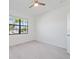 Well-lit bedroom featuring a ceiling fan and a large window overlooking the street at 2161 Gardenia Ave, Port Charlotte, FL 33953