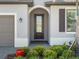 Elegant front entrance with a glass door, complemented by manicured shrubs and landscape at 2161 Gardenia Ave, Port Charlotte, FL 33953