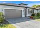 Beautiful one-story house boasts a spacious driveway, complemented by lush greenery and a modern design at 2161 Gardenia Ave, Port Charlotte, FL 33953