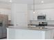 Bright kitchen features white cabinets, stainless steel appliances, granite countertops, and a central island at 2161 Gardenia Ave, Port Charlotte, FL 33953