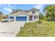 Charming two-story home with blue garage doors and shutters plus well maintained lawn at 2210 Mauritania Rd, Punta Gorda, FL 33983