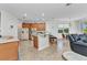 Open-concept kitchen featuring wood cabinetry, a breakfast bar and adjacent dining area at 2210 Mauritania Rd, Punta Gorda, FL 33983