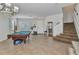Spacious living room with a pool table, stairs, and front entry at 2210 Mauritania Rd, Punta Gorda, FL 33983
