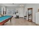 Open living area with a pool table, plenty of natural light, and a decorative display case at 2210 Mauritania Rd, Punta Gorda, FL 33983