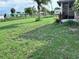 Green lawn space with some overgrown areas, featuring sparse landscape at 22187 Lasalle Rd, Port Charlotte, FL 33952