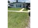 Well-maintained front yard with lush grass and a paved walkway at 22187 Lasalle Rd, Port Charlotte, FL 33952