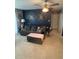 Cozy living room featuring a dark blue accent wall, sofa, and ceiling fan at 22187 Lasalle Rd, Port Charlotte, FL 33952