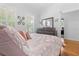 Bright bedroom features shuttered windows, wood floors, dresser with mirror, and decorative plates on the wall at 233 Durrance St, Punta Gorda, FL 33950