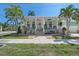 Inviting coastal home with a classic porch, lush landscaping, and vibrant palm trees at 233 Durrance St, Punta Gorda, FL 33950