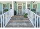 Inviting front porch with stone steps, white railings, and a charming turquoise exterior at 233 Durrance St, Punta Gorda, FL 33950