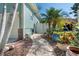 Paver walkway leads through a lush landscape with mature palms and colorful potted plants at 233 Durrance St, Punta Gorda, FL 33950