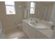 Bright bathroom featuring a shower, toilet, and large vanity with drawers and shelves at 260 Rotonda E Blvd, Rotonda West, FL 33947