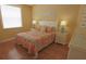 Well-lit bedroom featuring colorful bedding, side tables with lamps, and hard wood flooring at 260 Rotonda E Blvd, Rotonda West, FL 33947