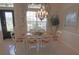 Dining room with tile floors, a chandelier, a light-colored table with six chairs, and a large window at 260 Rotonda E Blvd, Rotonda West, FL 33947