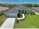Beautifully landscaped home featuring a well manicured lawn, palm trees, and a paved driveway leading to the garage at 260 Rotonda E Blvd, Rotonda West, FL 33947
