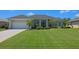 Beautiful single-story home boasts lush lawn, mature trees, and a well-kept landscape at 260 Rotonda E Blvd, Rotonda West, FL 33947