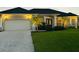 Charming home with a two-car garage, palm trees, manicured landscaping, and a patterned concrete driveway at 260 Rotonda E Blvd, Rotonda West, FL 33947