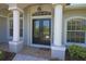 Elegant double front doors with glass inserts, flanked by columns, welcome you to this beautiful home at 260 Rotonda E Blvd, Rotonda West, FL 33947