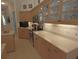 Kitchen featuring tile floors, wooden cabinets, and a tile backsplash with stainless steel appliances at 260 Rotonda E Blvd, Rotonda West, FL 33947