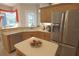 Bright kitchen features stainless steel refrigerator, light wood cabinets and island at 260 Rotonda E Blvd, Rotonda West, FL 33947