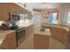 Kitchen featuring wood cabinets, stainless steel appliances, a center island, and tile floors at 260 Rotonda E Blvd, Rotonda West, FL 33947