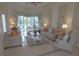 Spacious living room featuring tile floors, modern furniture with orange pillows, and a view of the pool at 260 Rotonda E Blvd, Rotonda West, FL 33947