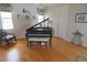 Bright room featuring beautiful hardwood floors, a grand piano and a comfortable chair at 260 Rotonda E Blvd, Rotonda West, FL 33947