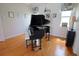 Well-lit living room with hardwood floors featuring a grand piano, creating an inviting space for entertainment and relaxation at 260 Rotonda E Blvd, Rotonda West, FL 33947