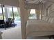 Bright bedroom with a four-poster bed, sitting area, and views of the pool at 260 Rotonda E Blvd, Rotonda West, FL 33947