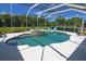 An enclosed pool features a spa with waterfall and ample patio space under a screened enclosure at 260 Rotonda E Blvd, Rotonda West, FL 33947
