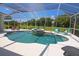 Enclosed pool area features a waterfall spa, lush landscaping, and comfortable seating under a screened enclosure at 260 Rotonda E Blvd, Rotonda West, FL 33947
